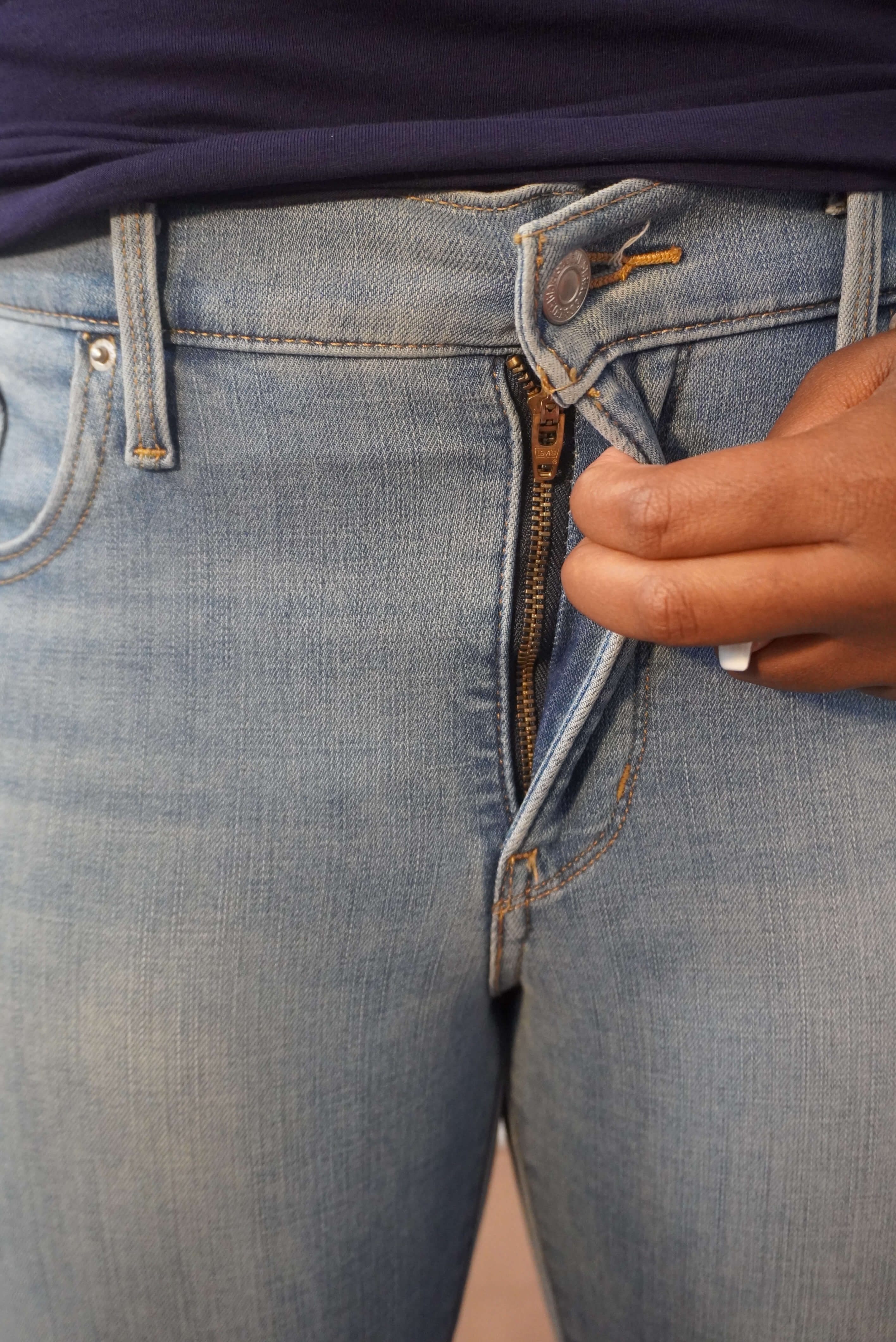 This image shows a close up of a fly zipper on a pair of Levi's jeans. You can pull the zipper up from the crotch and then button at the midriff area.