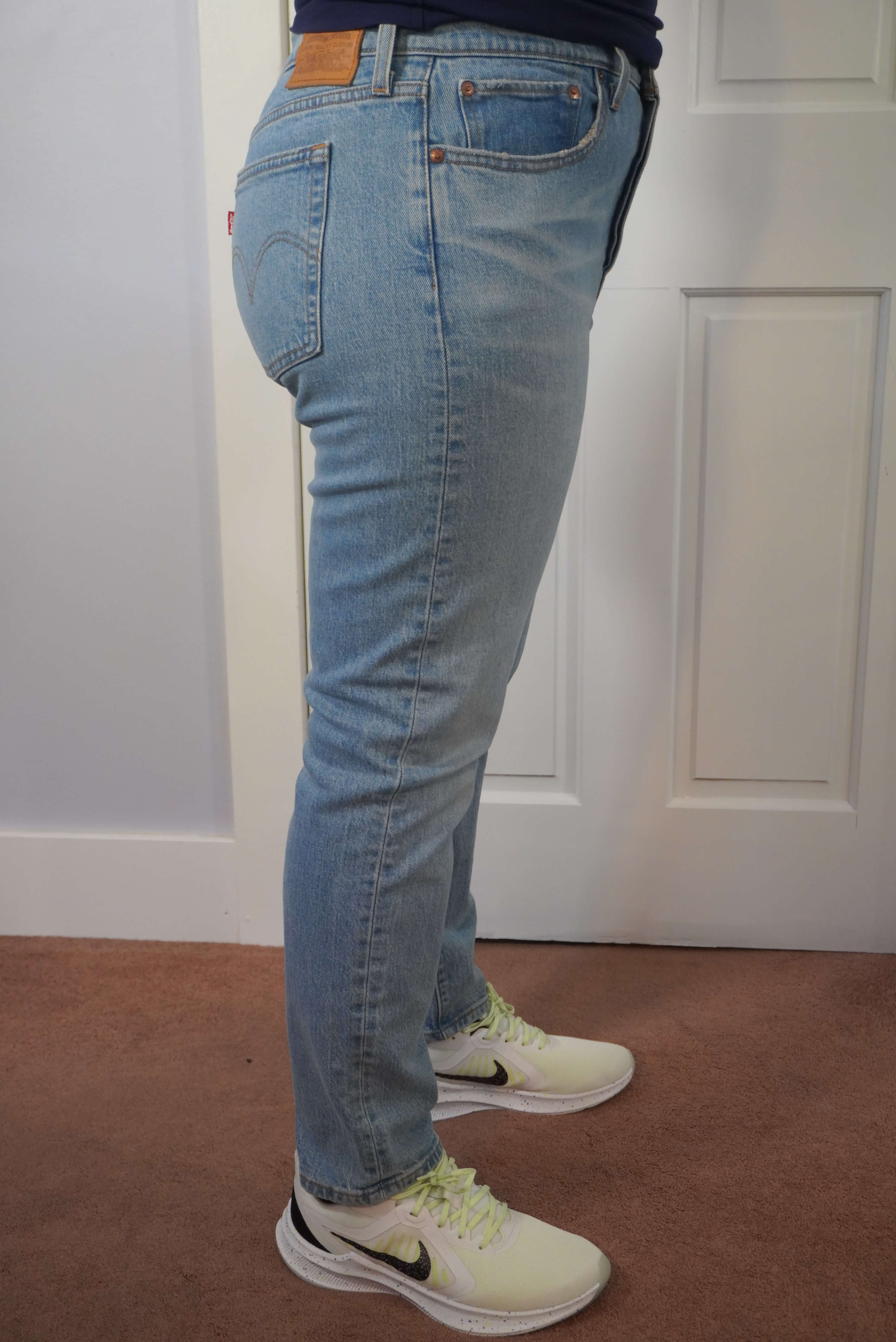 This image shows a side view of the author wearing a pair of Levi's Wedgie jeans in a light blue wash. This shows how the jeans are straight leg.
