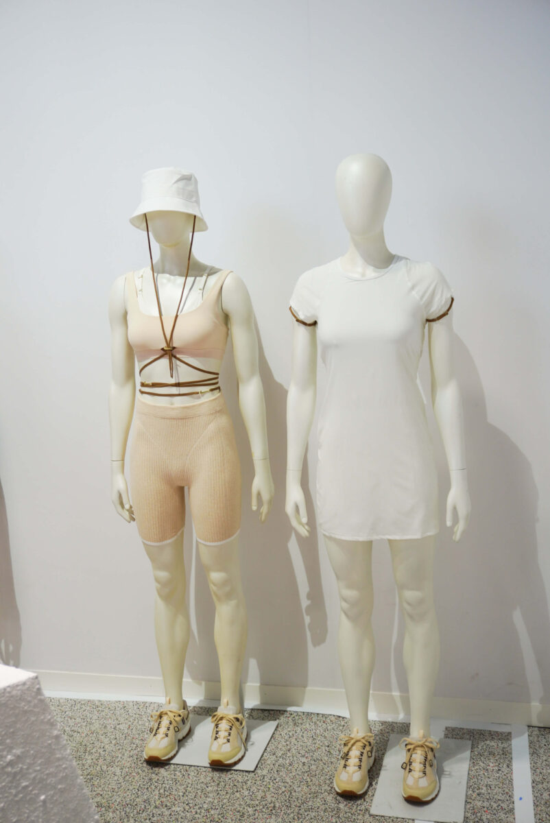 image of two mannequins dressed in white and beige activewear and dresses from the Nike x Jacquemus collaboration