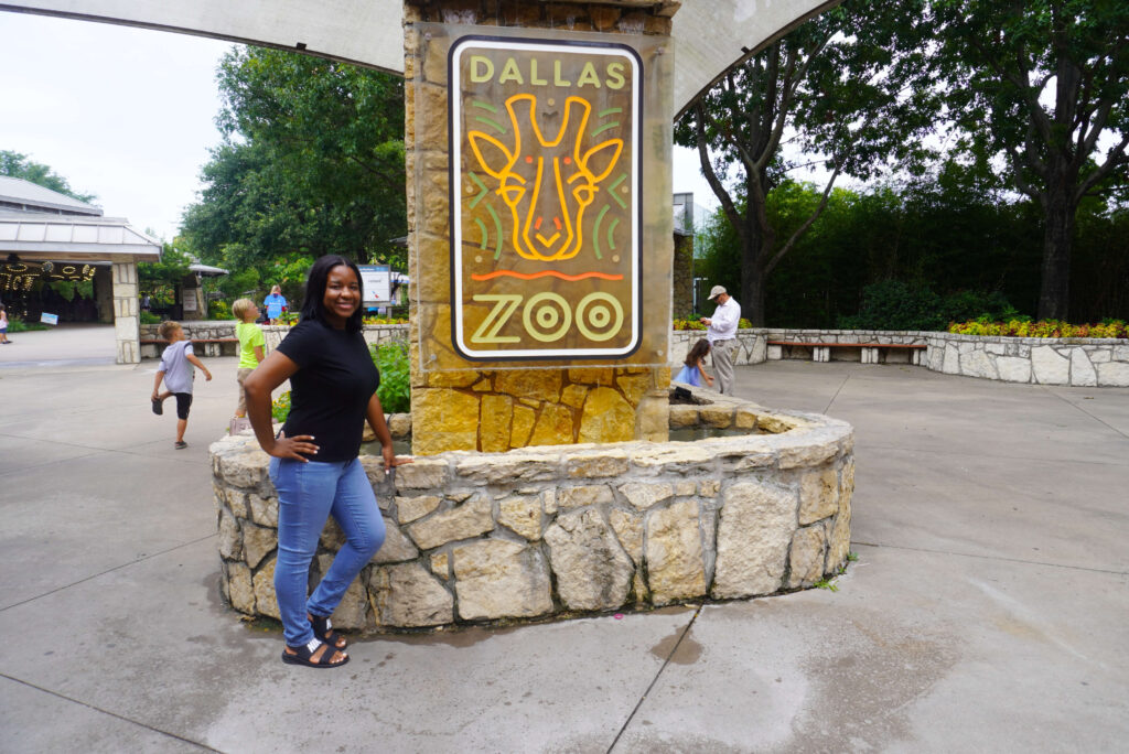 Image of me standing in front of the Dallas Zoo sign.