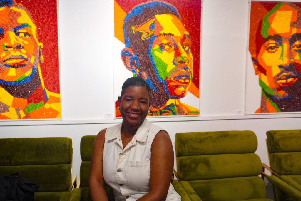 Image of me smiling in front of Harold Claudio's artwork at Art Basel week in Miami.