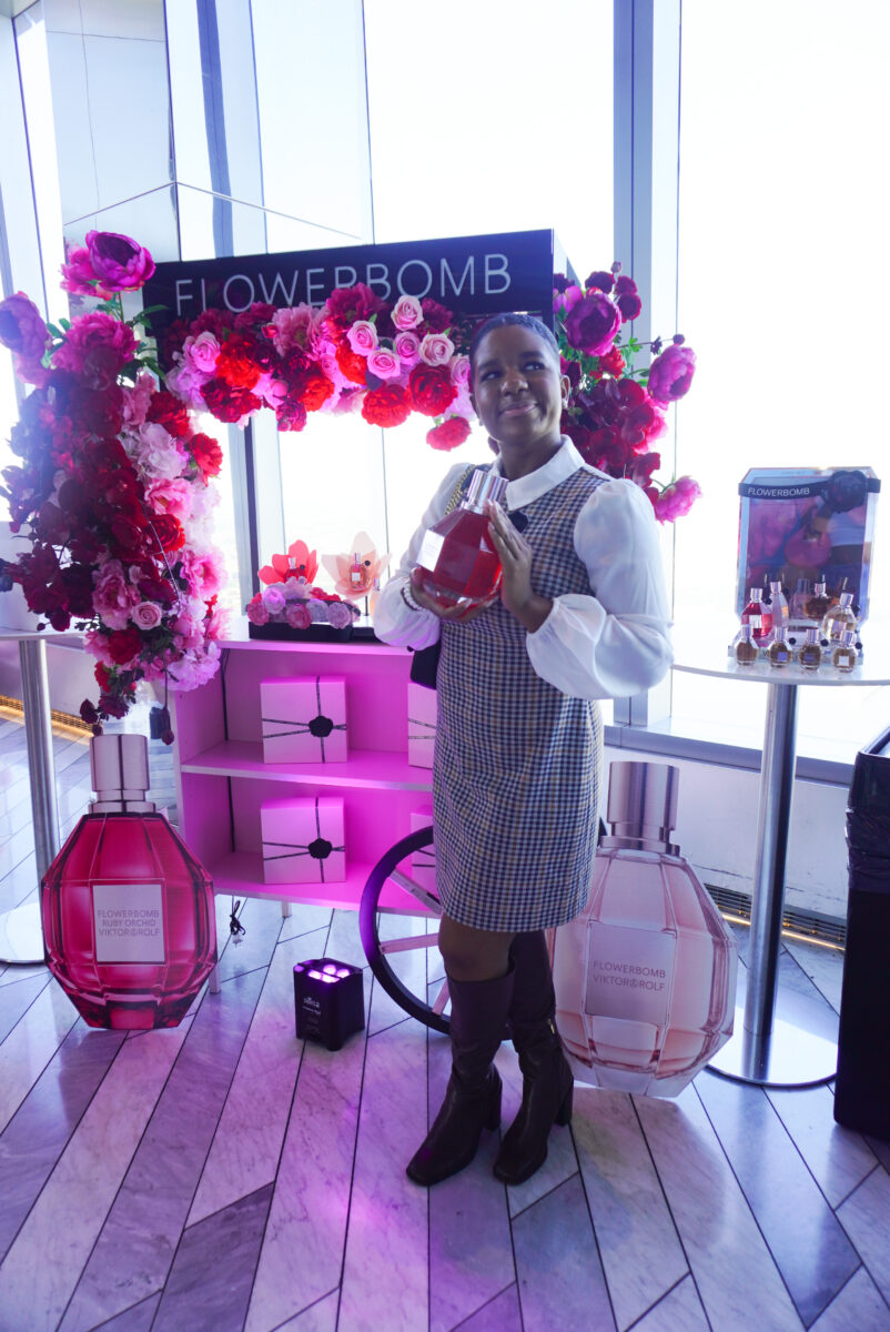 Image of me posing holding the Ruby Orchid fragrance in front of the Viktor & Rolf Flowerbomb perfume cart.