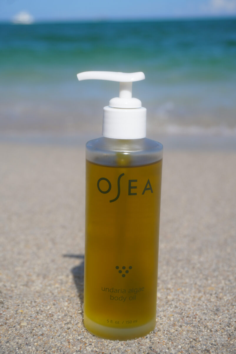 Image of the OSEA body oil sitting on the sand.