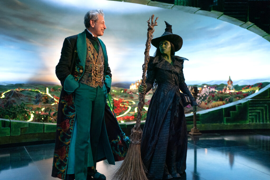 Image of Jeff Goldblum as the Wizard standing next to Cynthia Erivo as the Wicked Witch. 