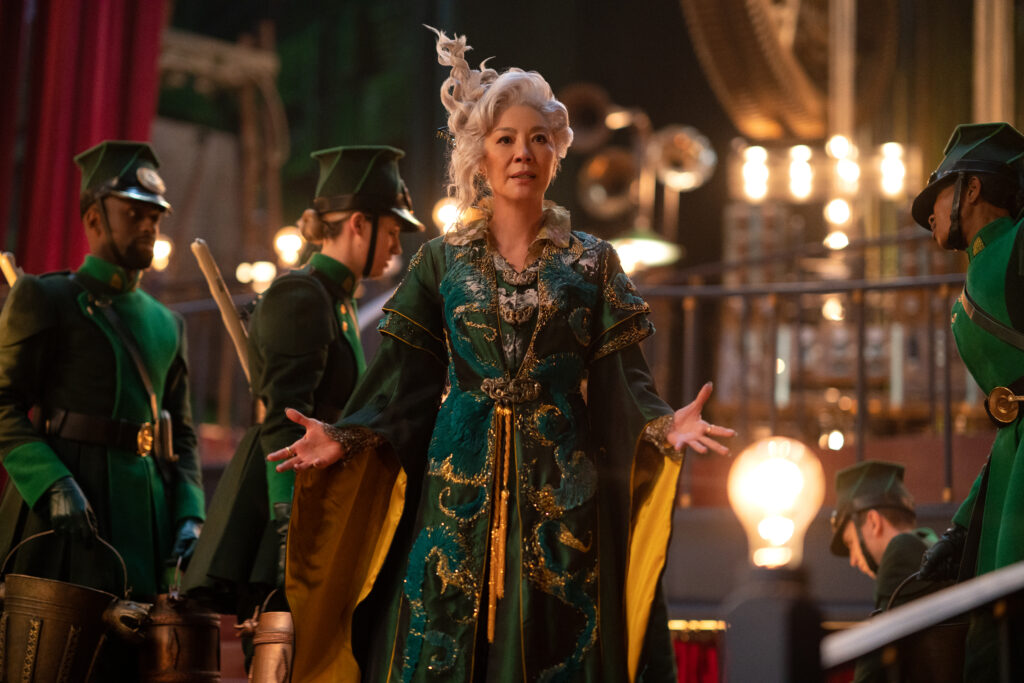 Image of Michelle Yeoh as Madame Morrible scheming on how to take down Elphaba the Wicked Witch of the West. 