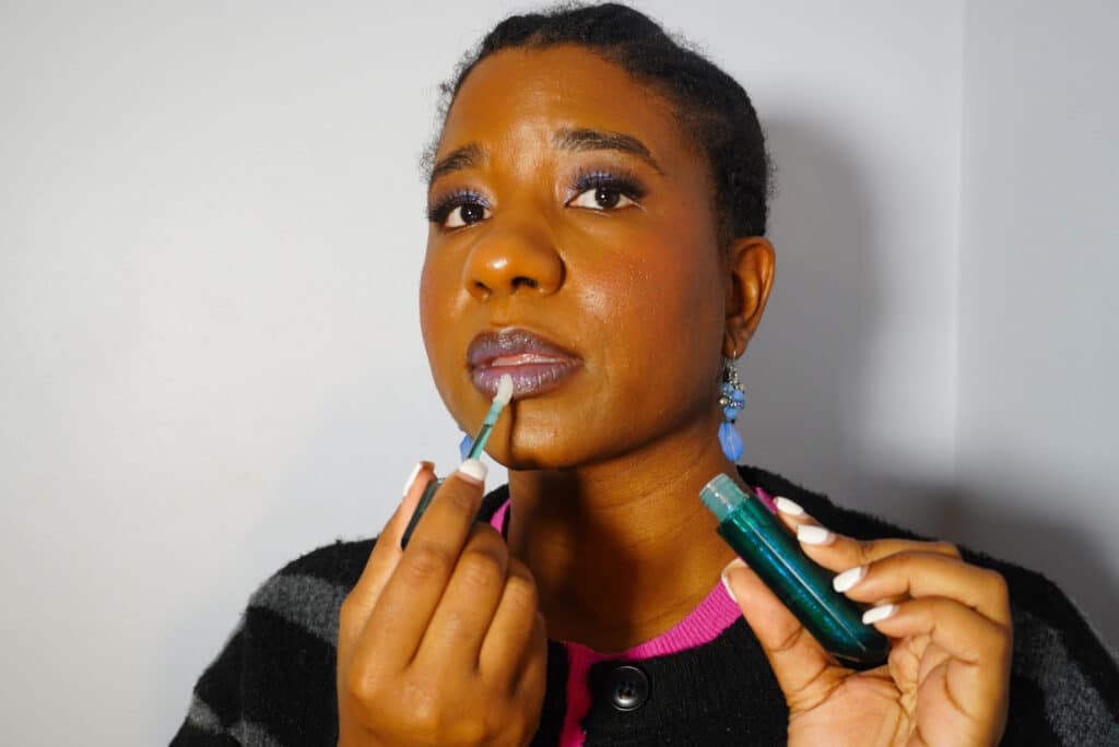 Image of me applying the Wicked x R.E.M .Beauty pH Adaptive Lip Oil.